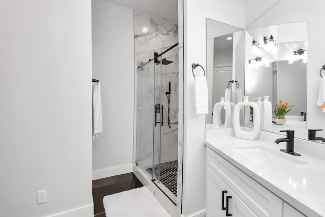 full bath with baseboards, vanity, and a marble finish shower