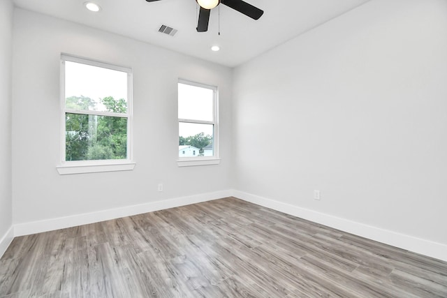 unfurnished room featuring wood finished floors, visible vents, and baseboards