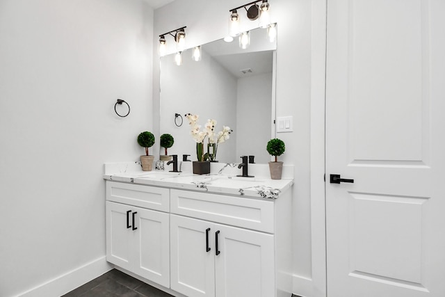 full bath featuring tile patterned flooring, a sink, baseboards, and double vanity