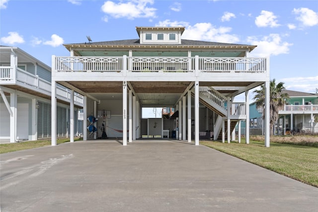 view of front of home featuring a carport, a front lawn, stairway, and driveway