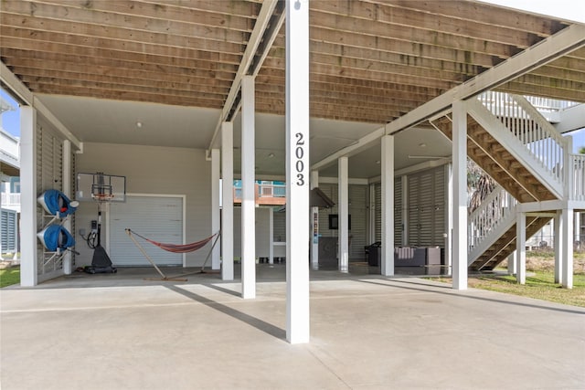 view of patio with stairs, a carport, and concrete driveway