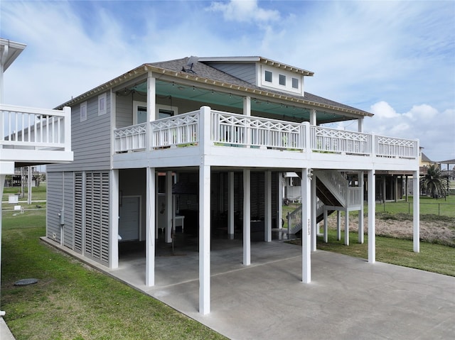 rear view of property with roof with shingles, a yard, a deck, a carport, and driveway