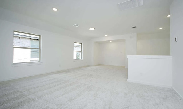 spare room with light carpet, visible vents, and recessed lighting