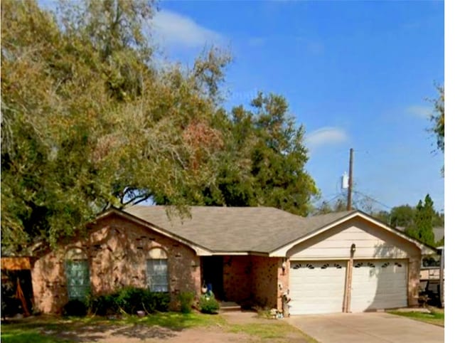 ranch-style house featuring an attached garage and concrete driveway