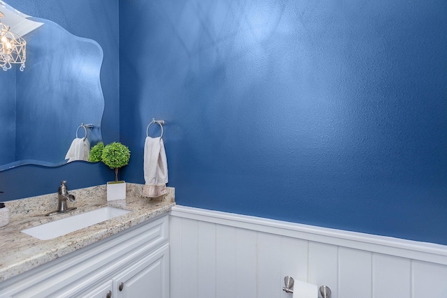 bathroom featuring wainscoting, vanity, and a notable chandelier