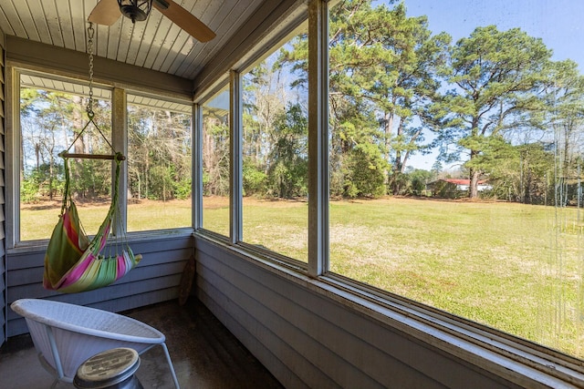 unfurnished sunroom with a healthy amount of sunlight, wooden ceiling, and ceiling fan