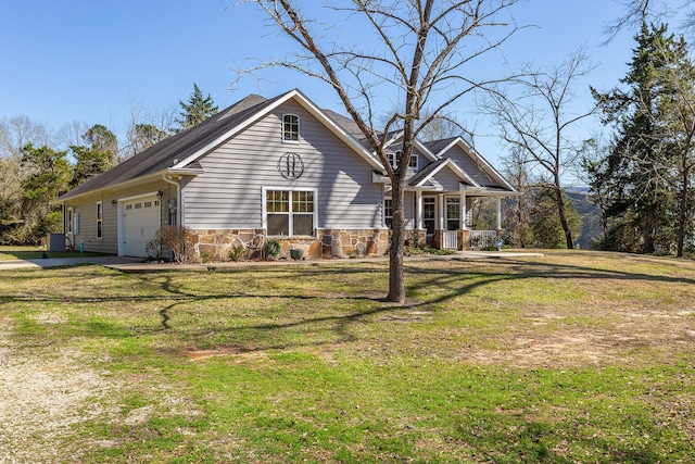 view of front of home with a garage, stone siding, a porch, and a front yard