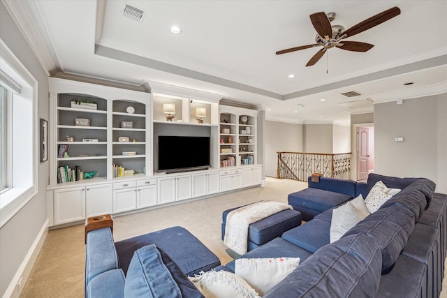 living room with ornamental molding, a raised ceiling, light carpet, and visible vents