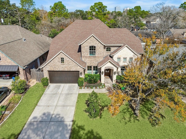 view of front facade with brick siding, fence, driveway, roof with shingles, and a front lawn