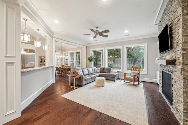 living area with baseboards, a fireplace, dark wood finished floors, and crown molding