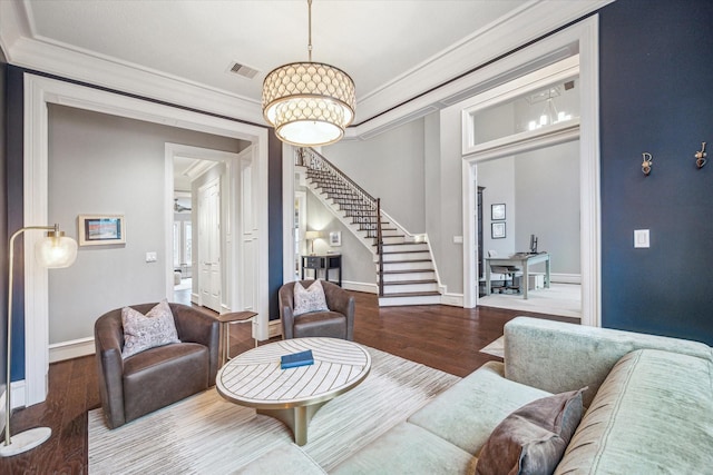 living room with baseboards, stairway, wood finished floors, and crown molding