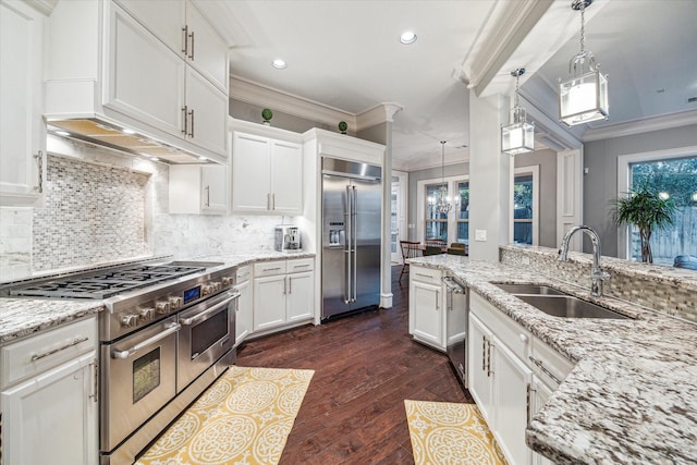 kitchen with high end appliances, white cabinets, crown molding, and a sink