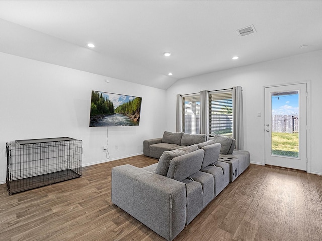 living room with recessed lighting, lofted ceiling, visible vents, wood finished floors, and baseboards