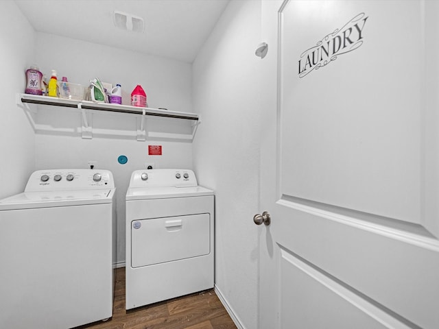 laundry area with laundry area, washing machine and dryer, visible vents, and dark wood-type flooring