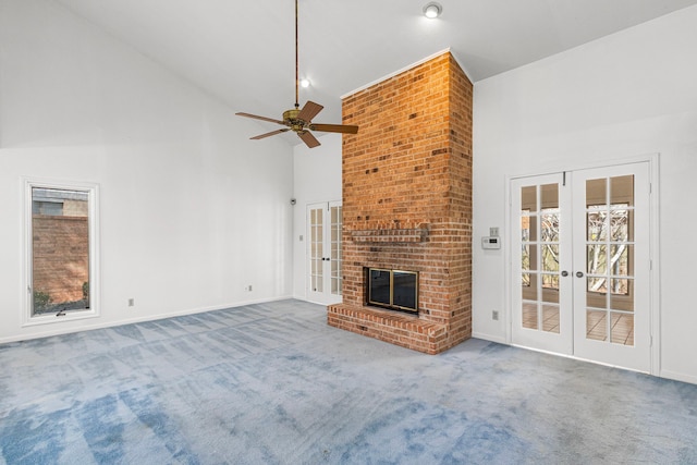 unfurnished living room with carpet floors, a healthy amount of sunlight, a fireplace, and french doors