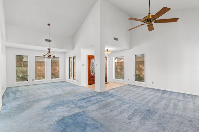 unfurnished living room with ceiling fan with notable chandelier, carpet floors, visible vents, and baseboards