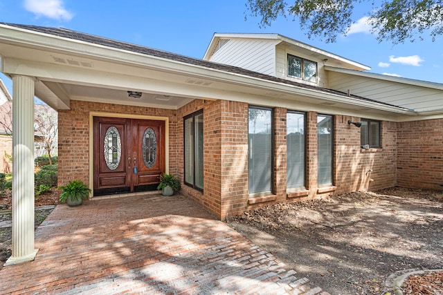 doorway to property featuring brick siding