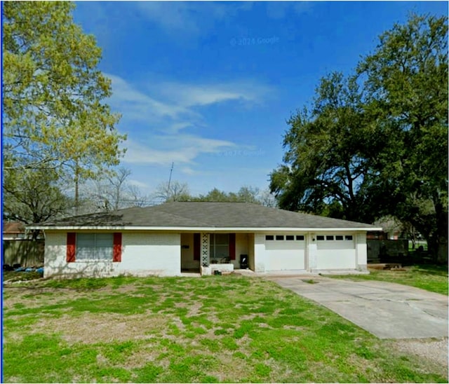 single story home featuring a front yard, concrete driveway, and an attached garage