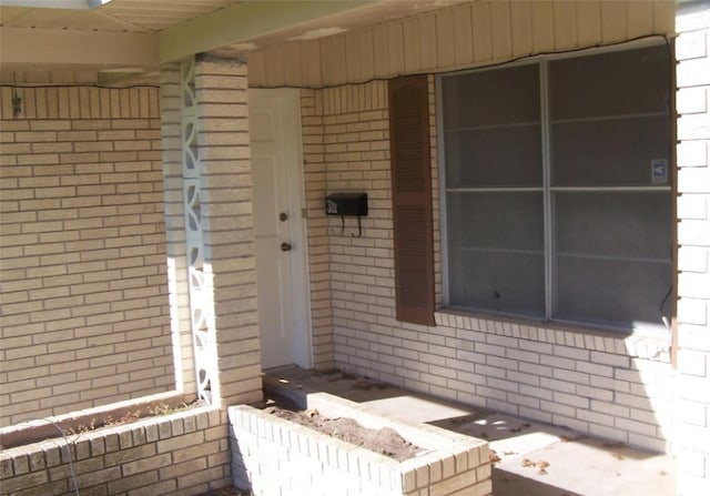 property entrance featuring brick siding