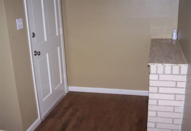 hallway with dark wood-style floors and baseboards