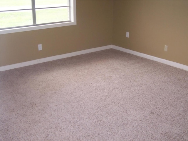 carpeted spare room featuring baseboards