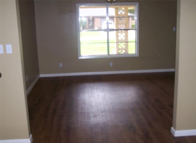 spare room featuring wood finished floors and baseboards