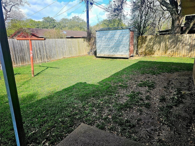 view of yard with a fenced backyard, an outdoor structure, and a storage unit