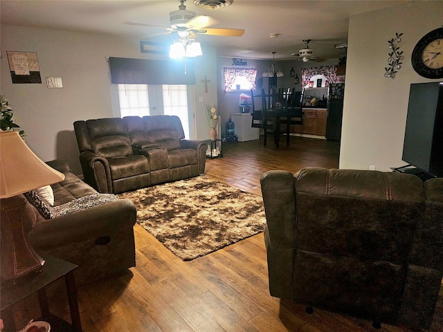 living area featuring wood finished floors, visible vents, and a ceiling fan
