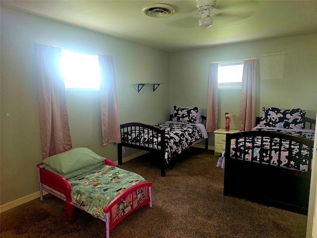 carpeted bedroom featuring baseboards, a ceiling fan, and visible vents