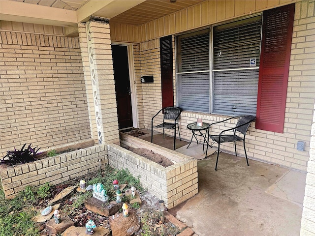 entrance to property with brick siding and covered porch