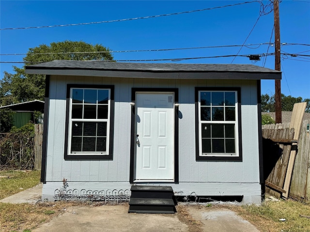 view of outbuilding featuring an outbuilding, fence, and entry steps