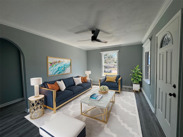 living area with arched walkways, a textured ceiling, wood finished floors, a ceiling fan, and ornamental molding