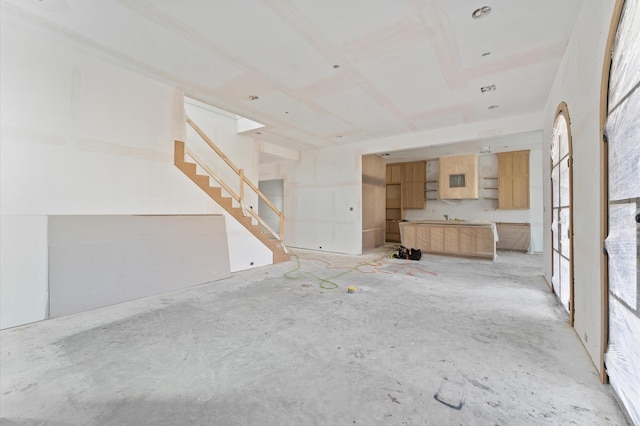 unfurnished living room featuring stairs