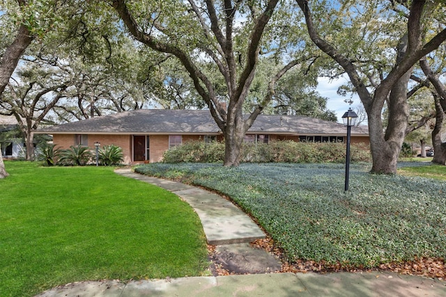 single story home featuring a front lawn and brick siding