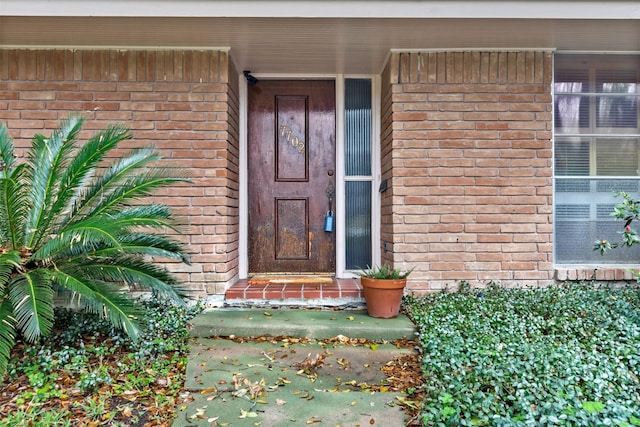 doorway to property with brick siding