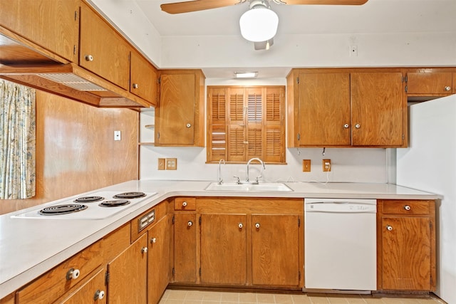 kitchen featuring white appliances, brown cabinetry, ceiling fan, a sink, and light countertops