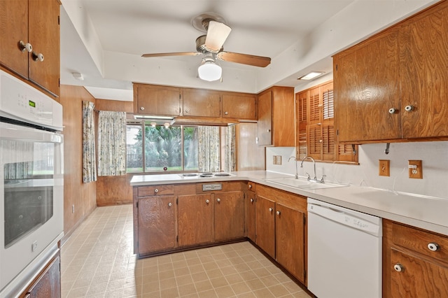 kitchen featuring white appliances, brown cabinetry, and light countertops