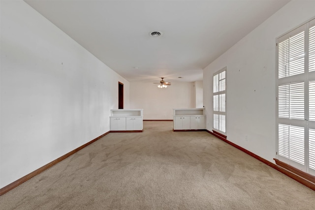 unfurnished room featuring visible vents, a ceiling fan, baseboards, and carpet floors