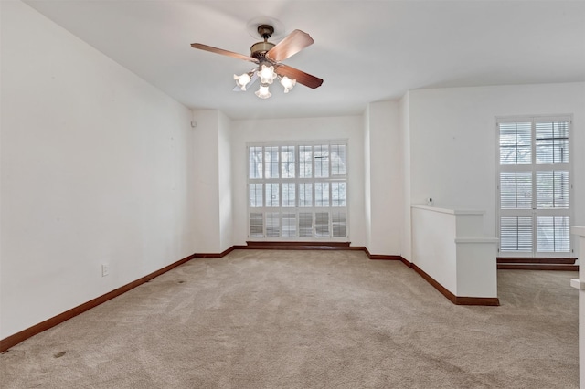 carpeted empty room with baseboards and ceiling fan