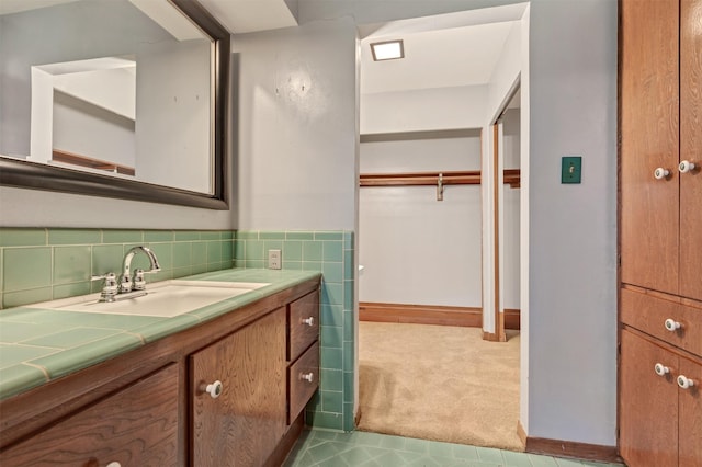 bathroom with vanity and tile walls