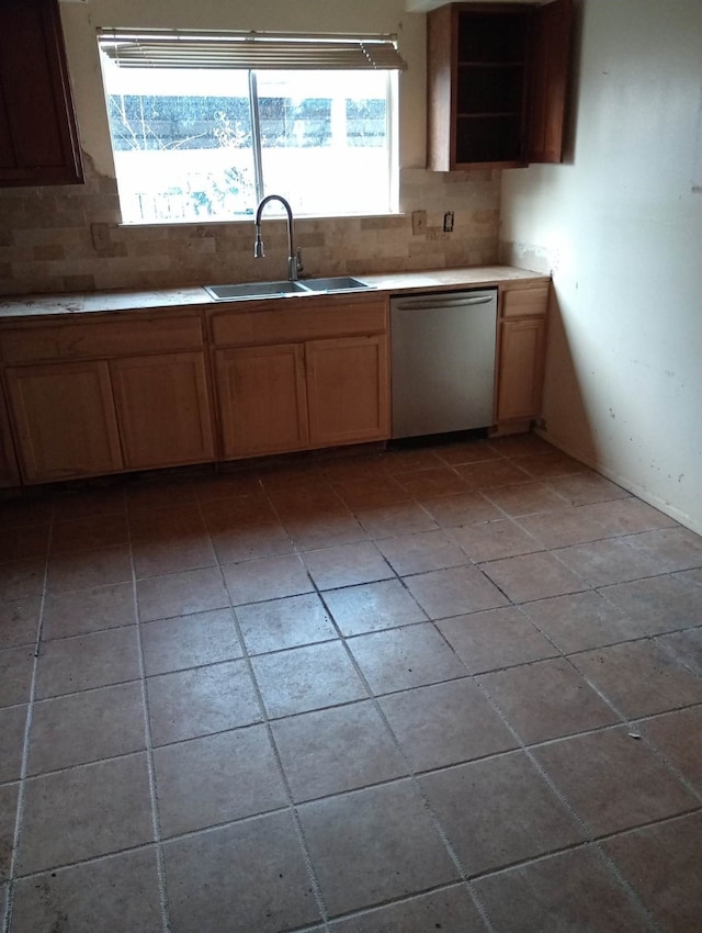 kitchen with light tile patterned floors, backsplash, stainless steel dishwasher, open shelves, and a sink