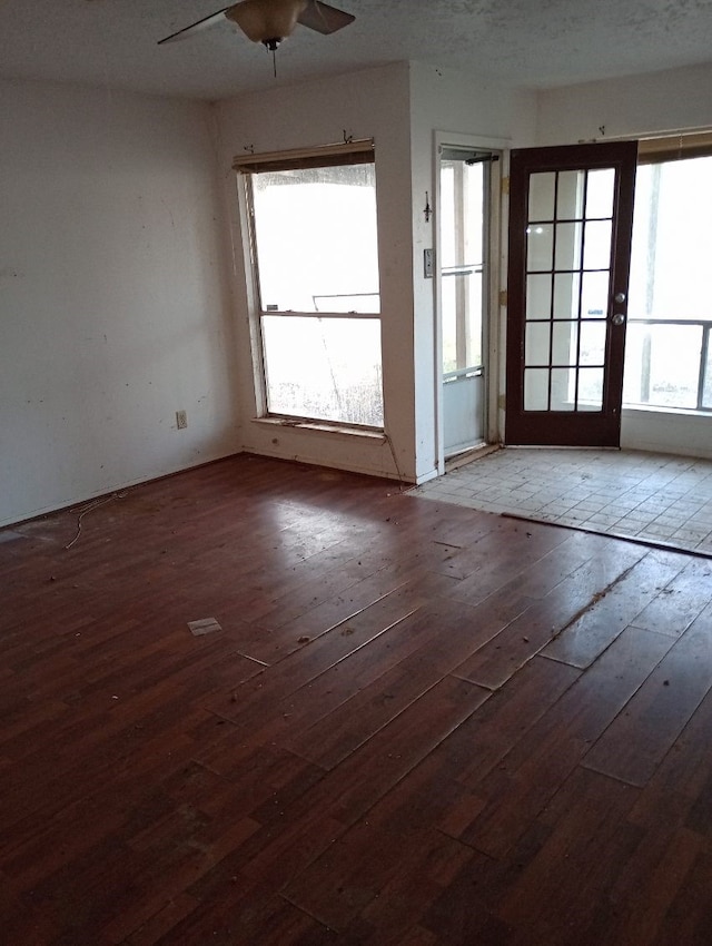 unfurnished room featuring a wealth of natural light, ceiling fan, and hardwood / wood-style floors