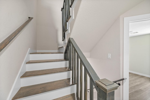 staircase featuring visible vents, baseboards, and wood finished floors