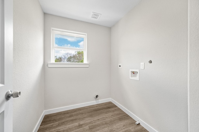 laundry area with laundry area, visible vents, wood finished floors, washer hookup, and electric dryer hookup