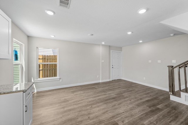 interior space with recessed lighting, wood finished floors, visible vents, baseboards, and stairway