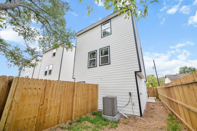 view of side of property with a fenced backyard and central AC unit