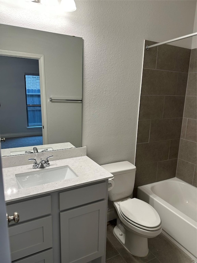 full bath with a textured wall, bathtub / shower combination, toilet, vanity, and tile patterned floors