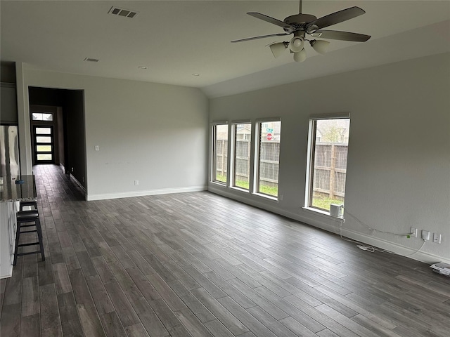 spare room with dark wood finished floors, visible vents, vaulted ceiling, ceiling fan, and baseboards