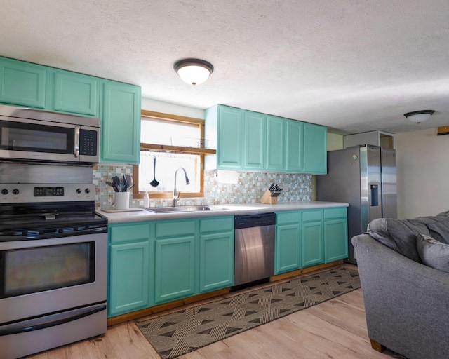 1821 County Road 201, Sargent, TX 77414 - kitchen with appliances with stainless steel finishes, tasteful backsplash, light countertops, light wood finished floors, and a textured ceiling