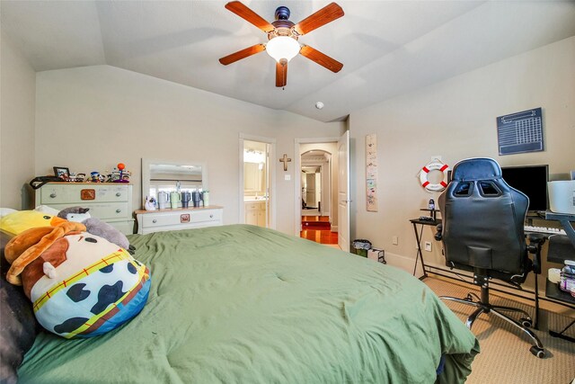 bedroom featuring arched walkways, baseboards, lofted ceiling, ensuite bath, and ceiling fan